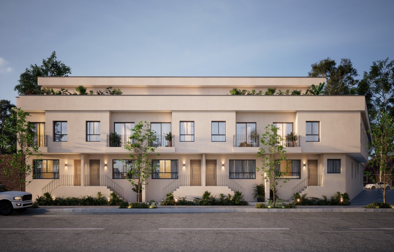 Fachada del Edificio Biera al atardecer: diez tríplex de líneas mediterráneas con jardineras y luz cálida